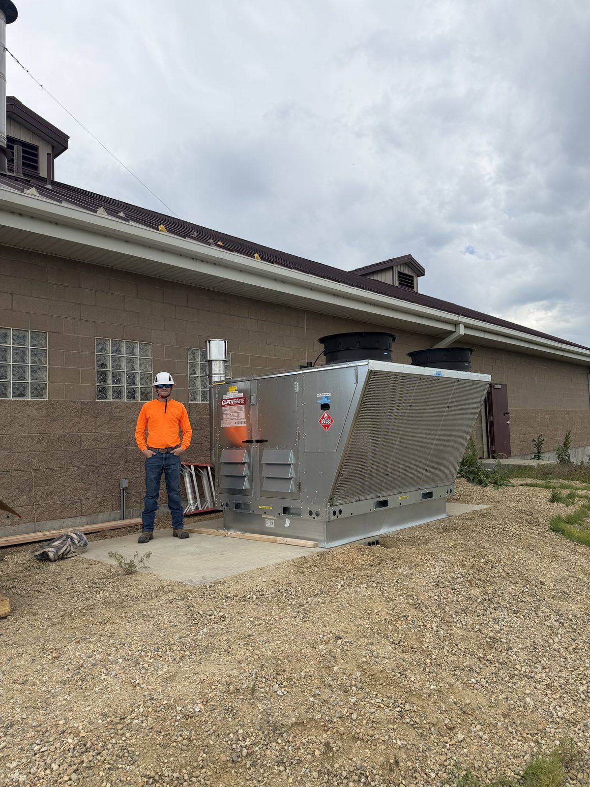 Longview Heating & Air technician on site servicing a CaptiveAire Paragon commercial rooftop HVAC unit