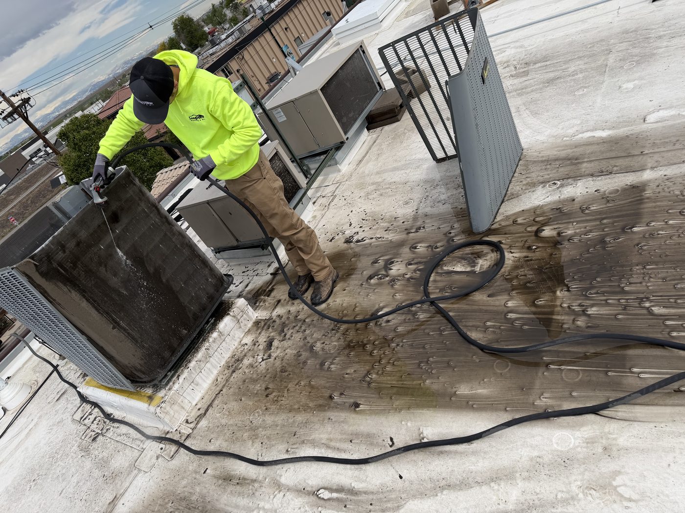 Longview technician cleaning a condenser coil during a maintenance visit