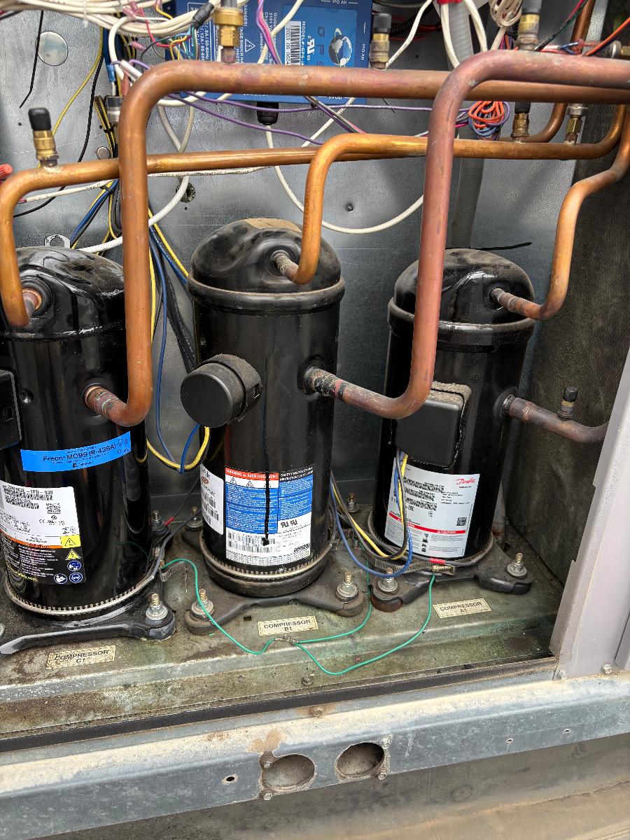 Scroll compressors and copper refrigerant piping inside a commercial condensing unit