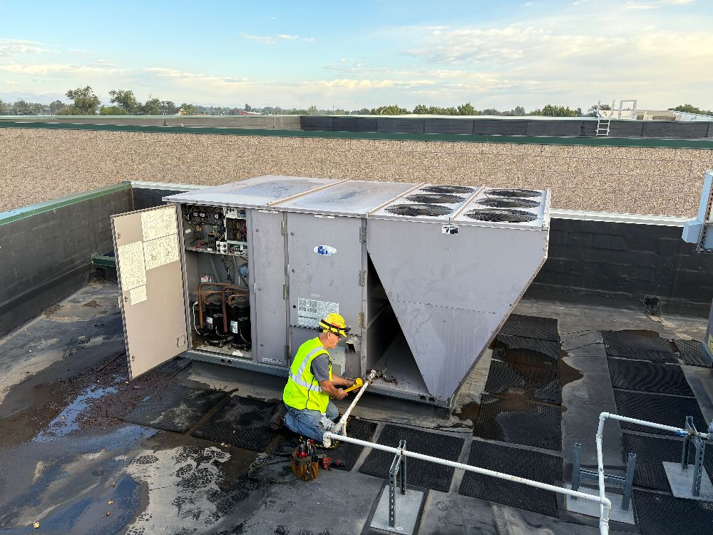 Longview technician servicing an open rooftop HVAC unit on a commercial building