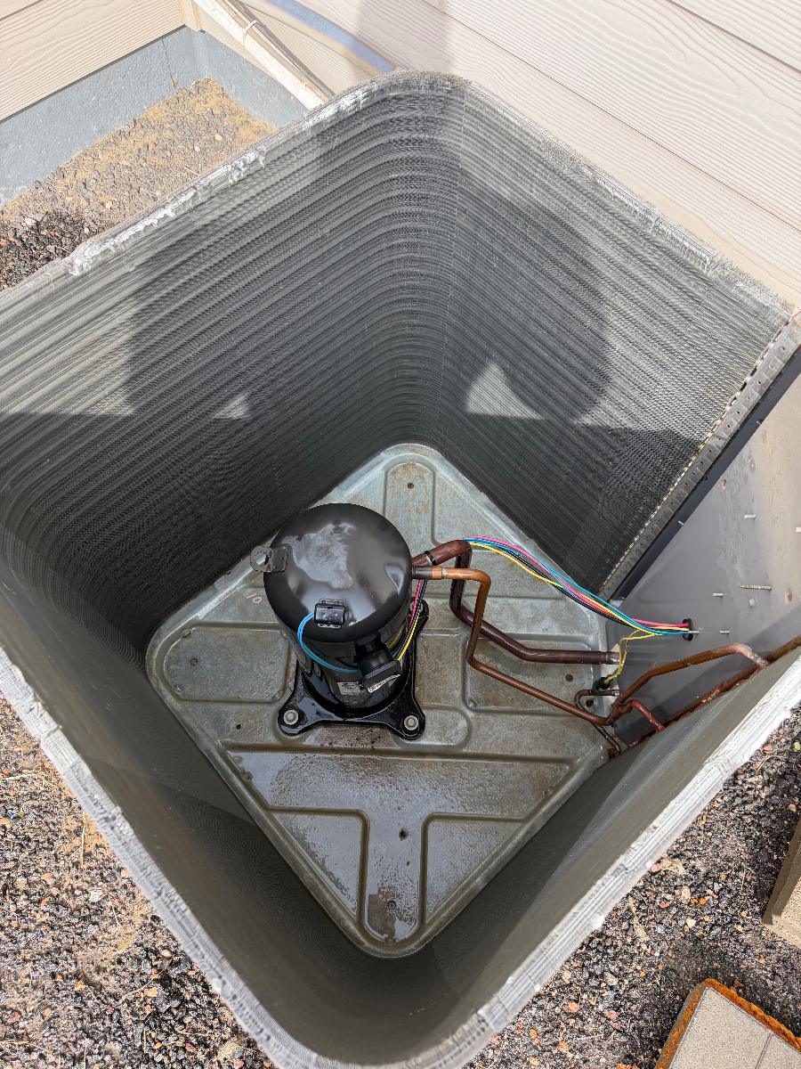 Top-down view into an outdoor AC unit during fan motor service