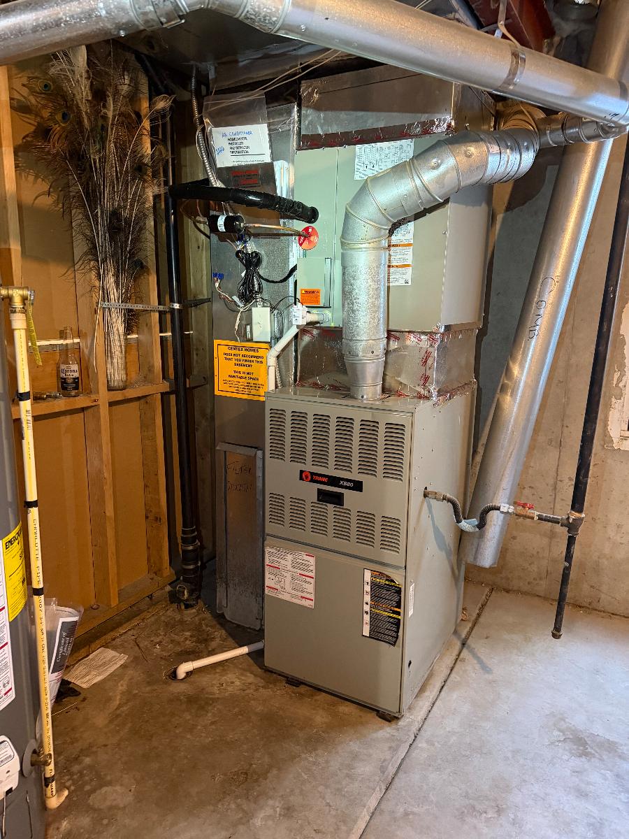 A furnace installed with ductwork and gas piping in a mechanical closet