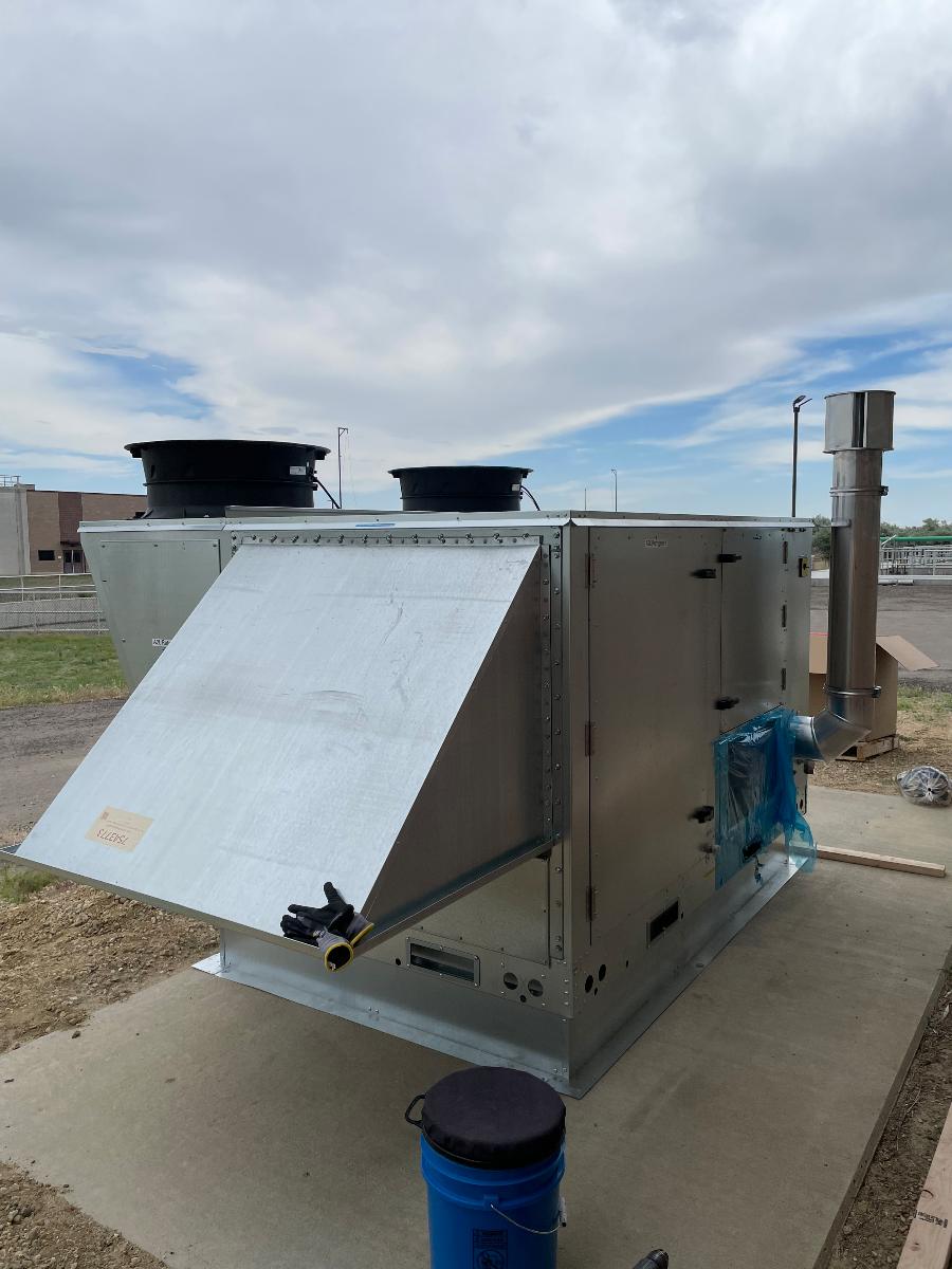 A commercial rooftop package unit with an access panel open for service